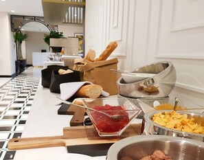 Un buffet proposant une variété de plats et agrémenté d’une planche à découper en bois.