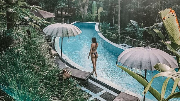 A pool surrounded by lush greenery and a wooden deck. - Song Broek Jungle Resort (Payangan)