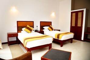 A hotel room with two beds, a nightstand, a chair, and a small table. - The Spring Villas (Kandy)