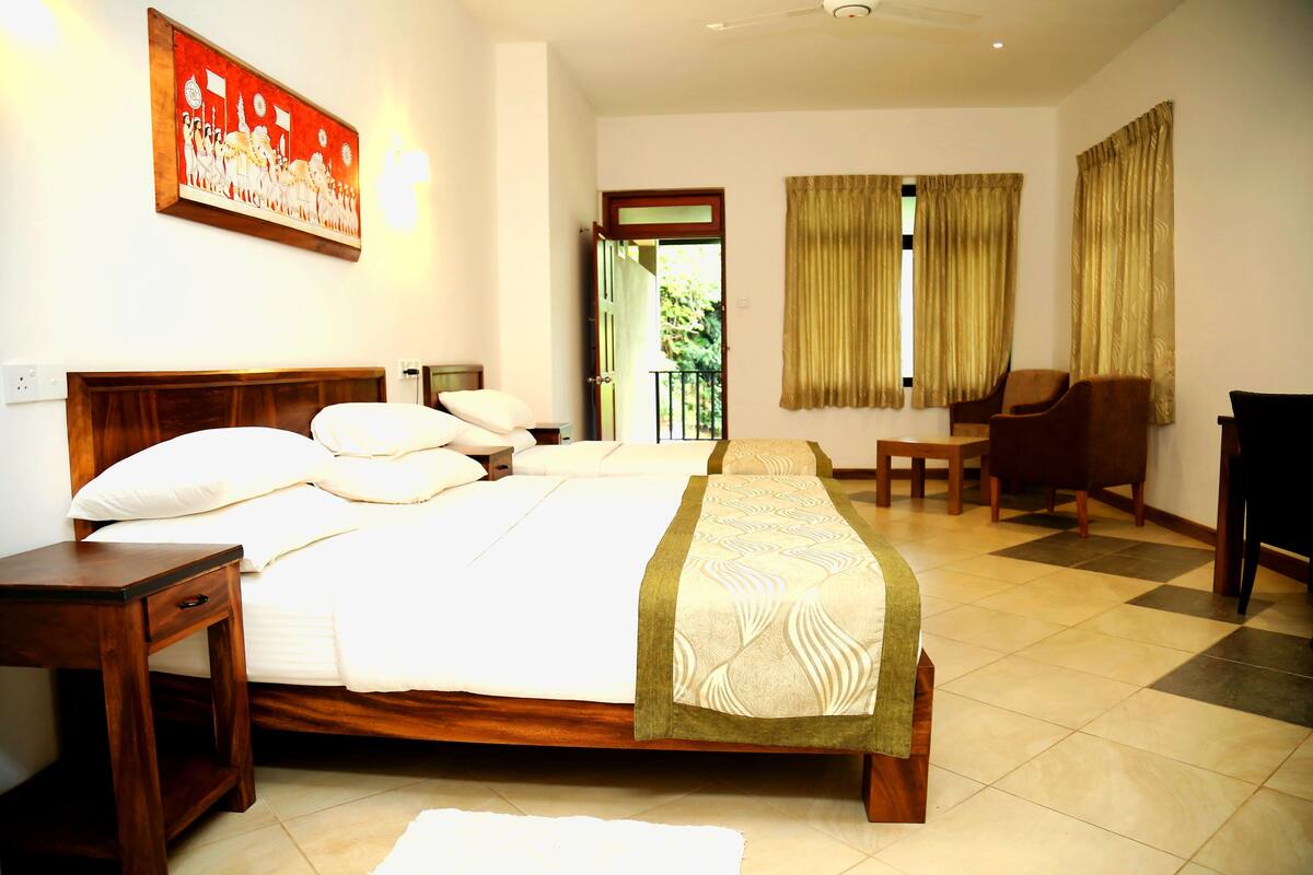 A hotel room with a large bed, a wooden headboard, a nightstand, a chair, and a desk.