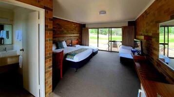 Een hotelkamer met een groot bed, een klein bed, een bureau, een televisie en een badkamer.