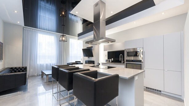 A modern kitchen with a central island, stainless steel appliances, and a sleek bar area.