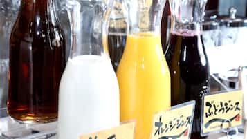 Variedad de bebidas en botellas de vidrio con etiquetas, incluyendo una bebida blanca, una anaranjada y una de color oscuro, probablemente en un bar o restaurante.