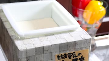 A white rectangular container on a gray tiled surface with a sign in Japanese.