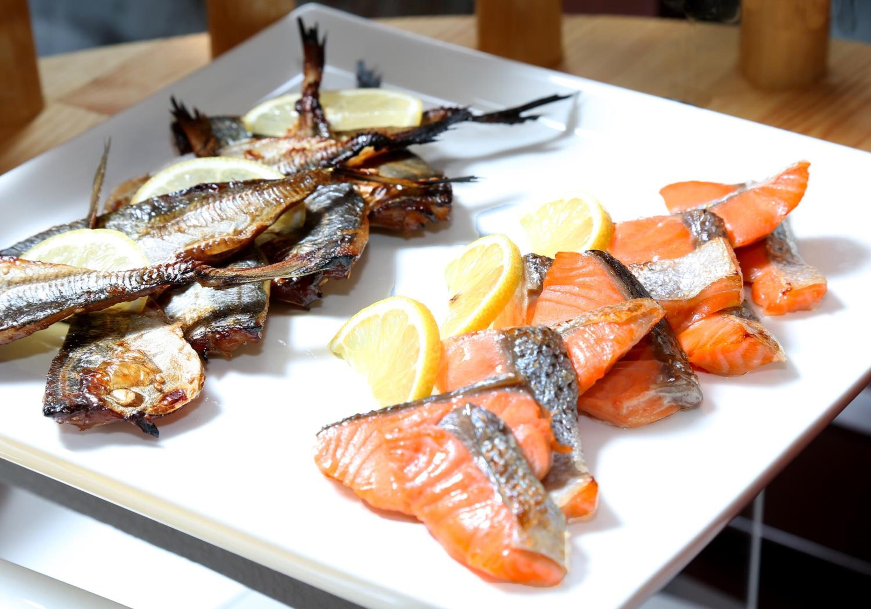 A plate of grilled fish and lemon slices.