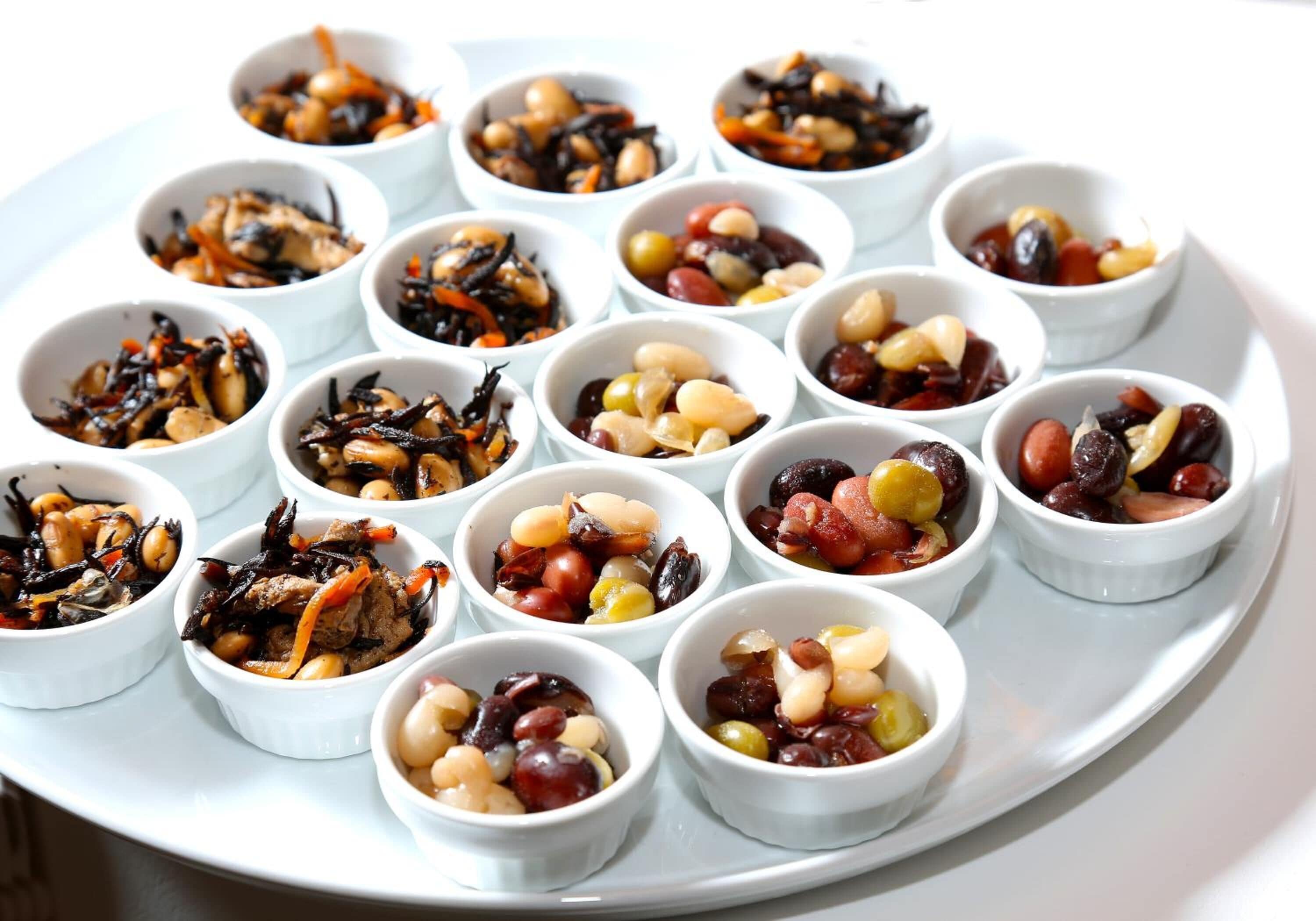 Una bandeja con recipientes pequeños que contienen nueces y frutas secas.