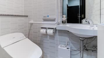 Un baño moderno con inodoro blanco, lavamanos y espejo.