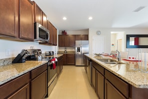 Features a double sink, stainless steel appliances, and granite countertops.