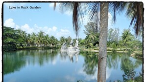 A serene lake in a garden with palm trees and a statue in the center. - 3 bdrm, 3 ba home with 24 hr security in private Villa. Located nr beach & pools (Kram)