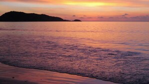 A sunset over a calm sea with a distant landmass. - 3 bdrm, 3 ba home with 24 hr security in private Villa. Located nr beach & pools (Kram)