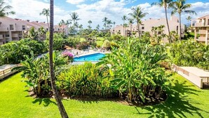 Un resort con piscina rodeada de exuberante vegetación y palmeras.