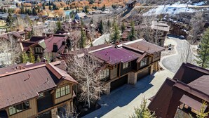 A residential area with houses featuring sloped roofs and a mountainous backdrop.