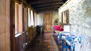 Un couloir aux murs en bois, avec un mur de pierre d’un côté, qui mène à une porte.