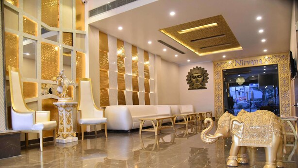 A luxurious lobby with a marble floor, white sofas, a reception desk, and a golden statue of an elephant. - Sallow Royal Suites (Amritsar)