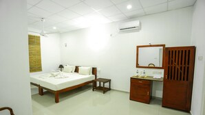 Una habitació d'hotel amb un llit, una taula de nit, un armari de fusta i un escriptori amb un mirall.