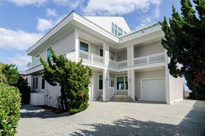 Une maison à deux étages avec un porche avant couvert et un garage.