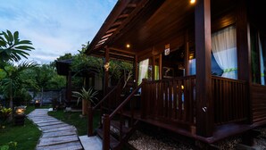 A wooden building with a porch, a stone pathway, and tropical plants. - Jenggala Hill (Lembongan Island)