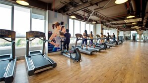 A gym with treadmills and elliptical machines, large windows, and a high ceiling with exposed pipes. - Sunrise City 2BR Luxury SWPool 30th (Ho Chi Minh City)