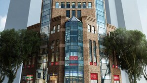 Un edificio alto y moderno con fachada de vidrio y una entrada destacada.