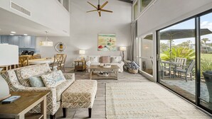 A spacious living room with a large sofa, a coffee table, and a dining area with chairs. - Unit 37, Sea Haven, 2 Bedroom Beach Condo (Panama City Beach)