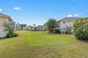 A residential area with houses, a well-maintained lawn, and a clear sky.