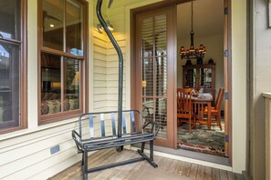 A bench outside a house with a dining area visible through a glass door. - Lodges 1140 | Shuttle | Shared Hot Tub (Mammoth Lakes)