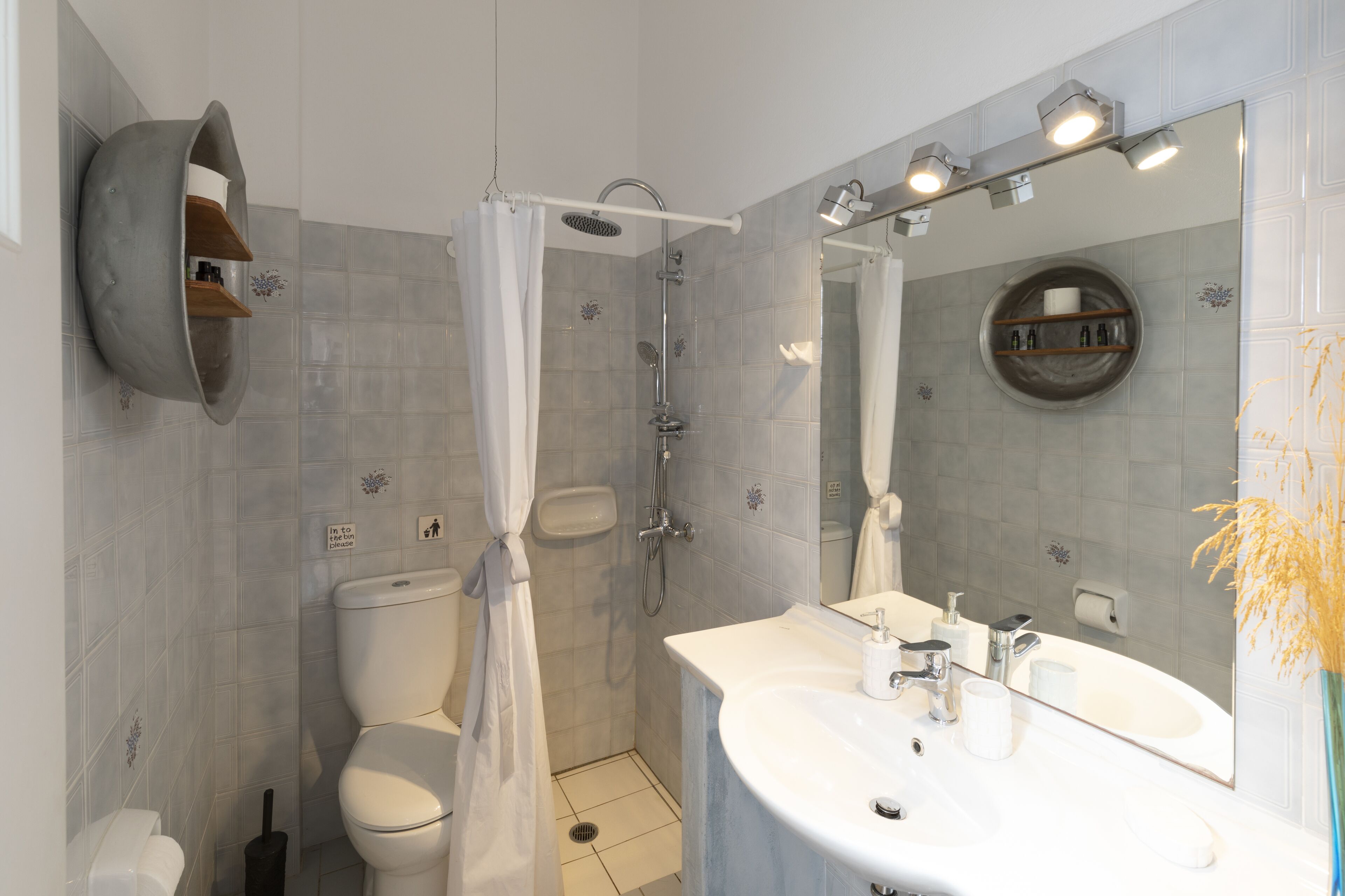 A modern bathroom with a toilet, shower, and sink.