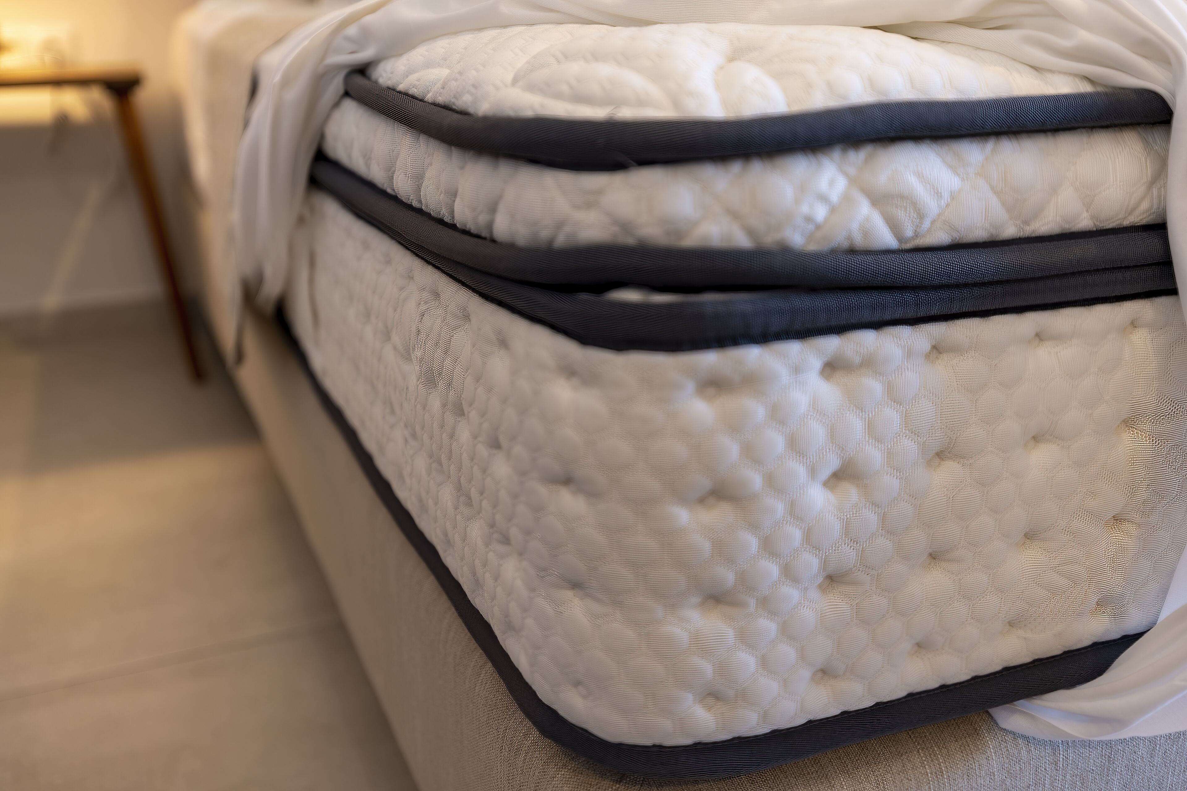 A mattress with a quilted cover and black edge detailing.