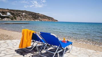 En la playa, sillas reclinables de playa, sombrillas