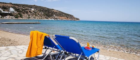 Na praia, espreguiçadeiras, guarda-sóis