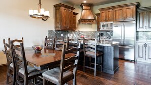 A spacious kitchen with wooden cabinets, a central island, and stainless steel appliances. - Canyons Townhome, Views & Gondola Access (Park City)