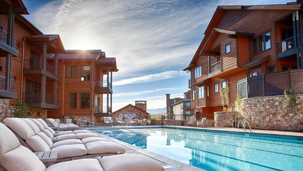 A poolside area with lounge chairs and a clear view of a pool. - Canyons Townhome, Views & Gondola Access (Park City)