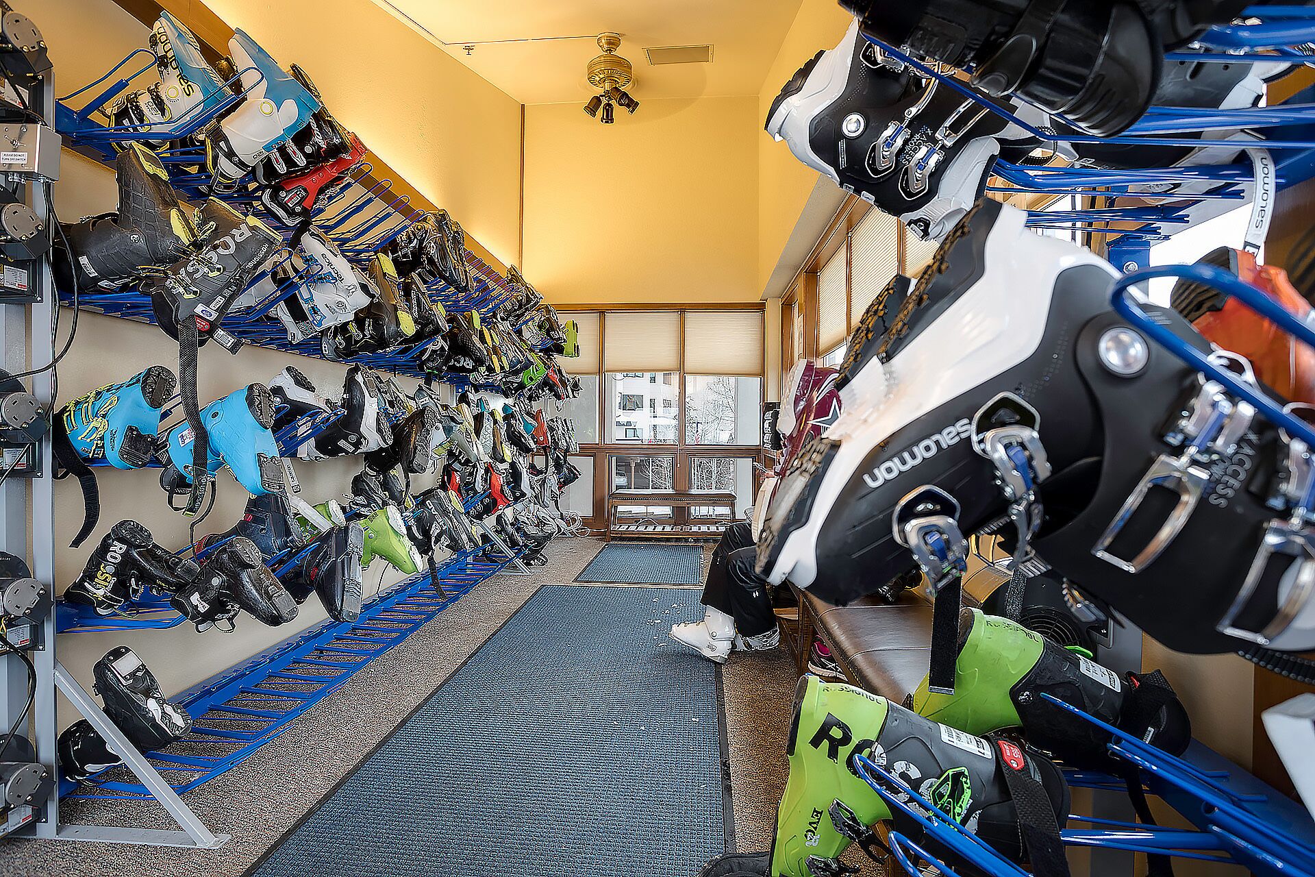 A shoe storage room with multiple racks filled with various types of athletic shoes.