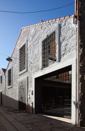 A building with a white facade, two visible windows with metal bars, and a door with a number '7' sign. - 7g Roaster Apartments (Vila Nova de Gaia)
