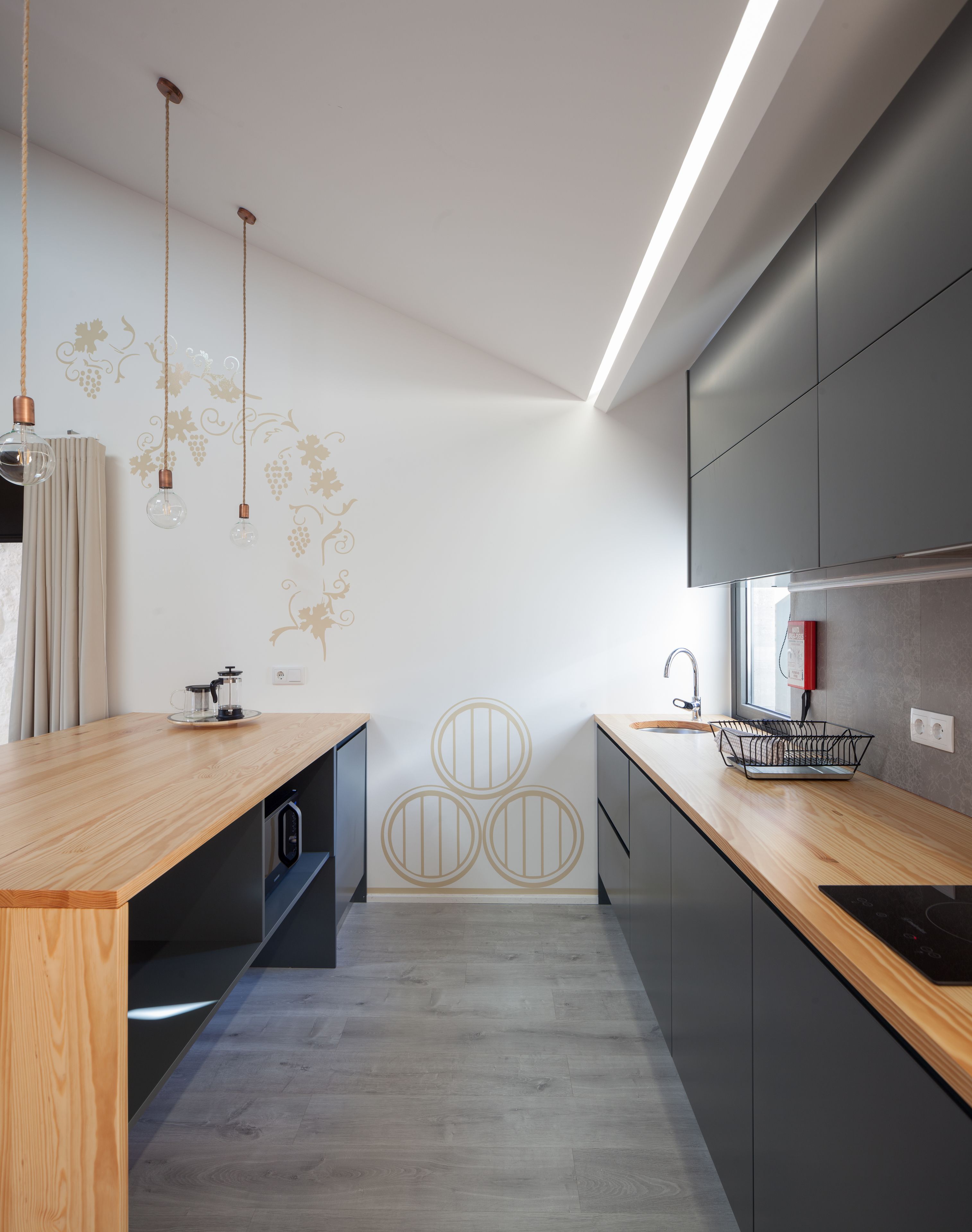 A modern kitchen with wooden countertops, a built-in oven, and a stainless steel sink.