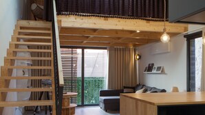 A modern interior with a wooden staircase, a dining area, and a balcony with a view. - 7g Roaster Apartments (Vila Nova de Gaia)
