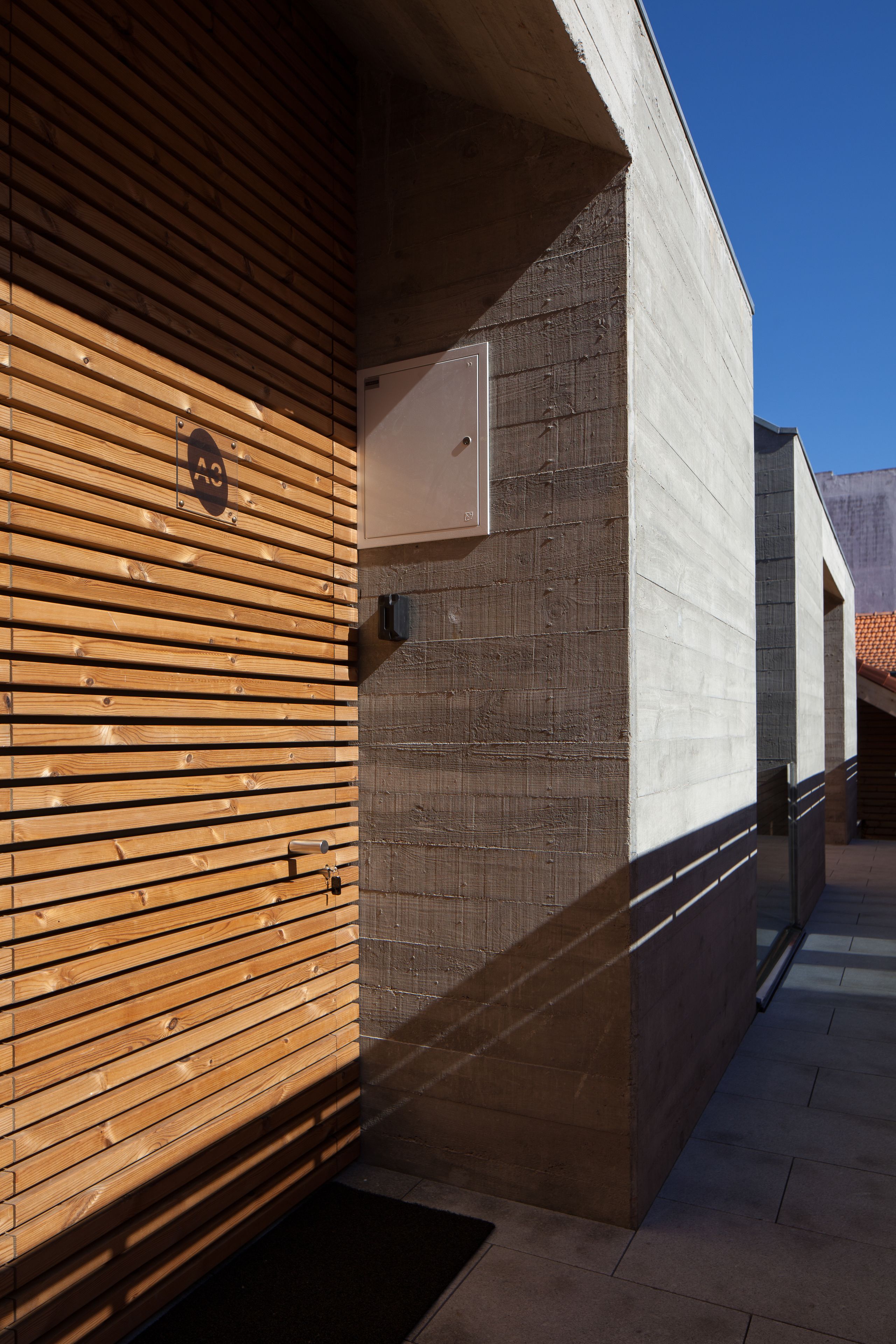 Un bâtiment doté d’une façade à lattes de bois et d’une partie en béton.