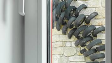 Une porte avec une poignée blanche et une fenêtre avec un mur en pierre et des joints en caoutchouc noir.