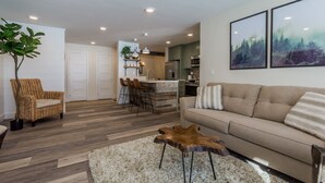 Un salon moderne avec un canapé, une table basse et un coin repas équipé de tabourets de bar.