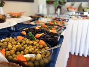 A buffet table with various food items including olives, carrots, and black beans.