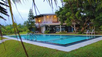 Relax on the balcony overlooking the pool and lush surroundings.