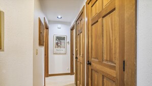 Un couloir avec des portes en bois et un tableau encadré accroché au mur.