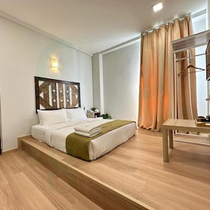 A modern hotel room with a bed, a small table, and a view of the outdoors. - S8 Boutique Hotel (Sepang)