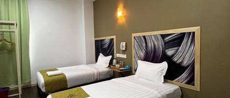 Quarto de hotel com duas camas, cortina verde, luminária na parede e um quadro.
