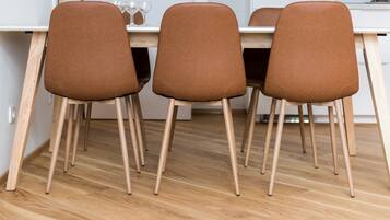 A dining area with a wooden table and four brown chairs with wooden legs.