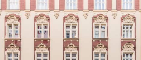 A building facade with multiple windows, ornate architectural details, and a symmetrical design.