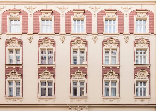 A building facade with multiple windows, ornate architectural details, and a symmetrical design.