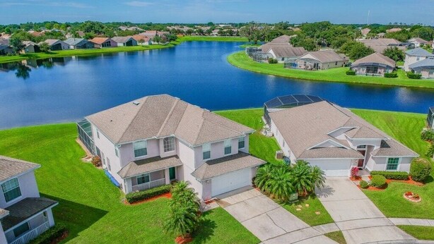 A residential area with houses, a lake, and a well-maintained lawn.