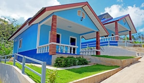 A two-story house with a blue exterior, white balcony railings, and a red roof. - Theppahrak Home (Takua Pa)