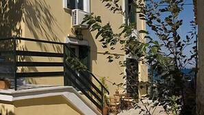 A building with a beige exterior, a black railing, and a staircase leading up to a door.